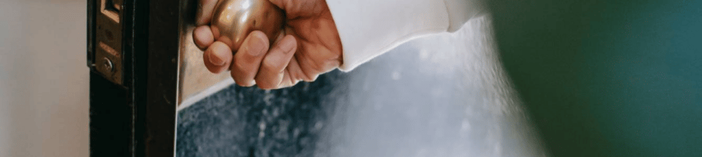 Main ouvrant la porte d'une maison de personne âgée